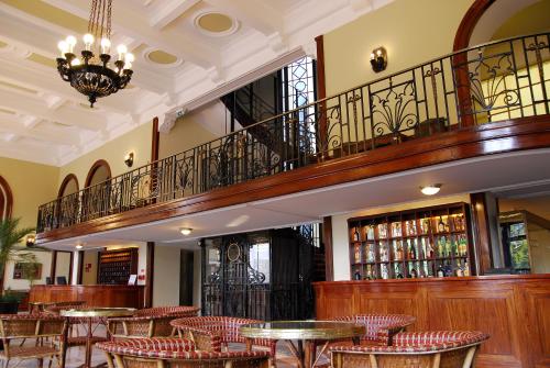 a restaurant with tables and chairs and a staircase at Curia Palace Hotel & Spa in Curia