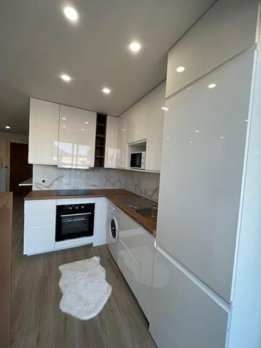 La cuisine est équipée de placards blancs et d'un lave-vaisselle. dans l'établissement Appartement Centre villes Climatisées Terrasse, à Cagnes-sur-Mer