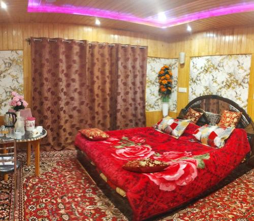 a bedroom with a large bed with a red blanket at Sheraz Guest House Ziran Gulmarg in Gulmarg