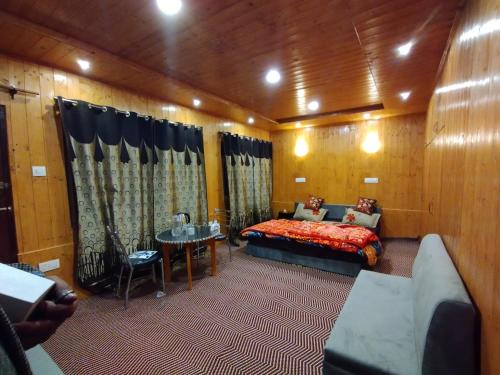 ein Schlafzimmer mit einem Bett und einem Tisch in einem Zimmer in der Unterkunft Sheraz Guest House Ziran Gulmarg in Gulmarg