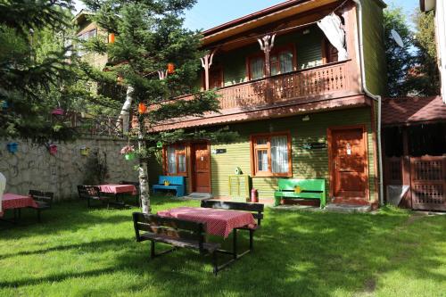 a house with a table and benches in the yard at ABANT DORT MEVSİM KONAĞI HOSTEL in Dereceören