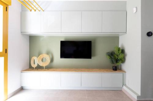 a living room with white cabinets and a flat screen tv at Estudio moderno y acogedor en Madrid Rio nº6 in Madrid