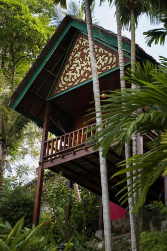 a tree house in a forest with palm trees at Casa Nemo Beach Resort & Spa in Sabong