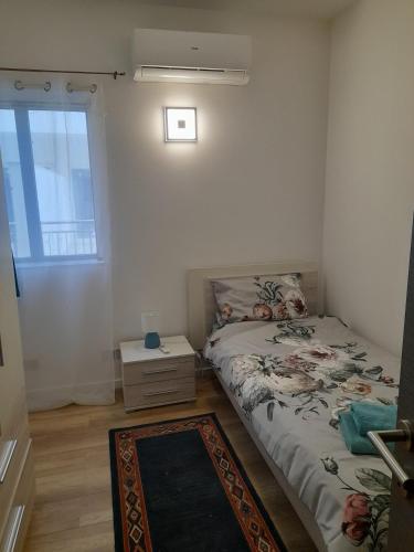a small bedroom with a bed and a window at Cosy 4 Bedroom Apt with use of Pool in St Paul's Bay