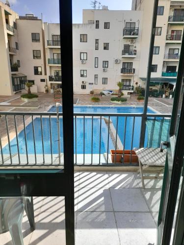 a balcony with a view of a swimming pool at Cosy 4 Bedroom Apt with use of Pool in St Paul's Bay