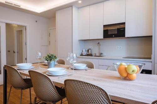a dining room table with chairs and a kitchen at The Zentral Suites & Apartments in Seville