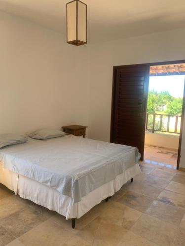 a bedroom with a bed and a large window at Casa do Português in Aracati