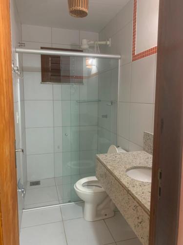 een badkamer met een douche, een toilet en een wastafel bij Casa do Português in Aracati