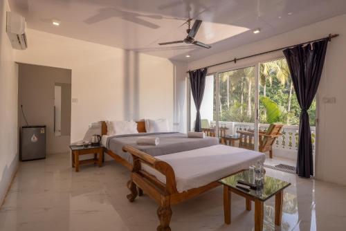 a bedroom with a bed and a balcony at Crystall Goa, Onyx Edition in Palolem
