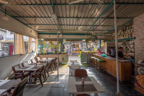 a restaurant with wooden tables and chairs and a street at Crystall Goa, Onyx Edition in Palolem