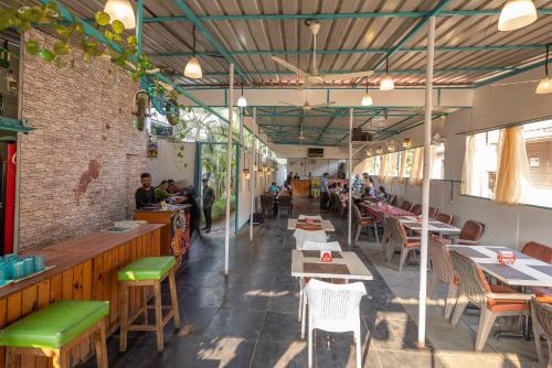 een restaurant met tafels en stoelen en een bakstenen muur bij Crystall Goa, Onyx Edition in Palolem