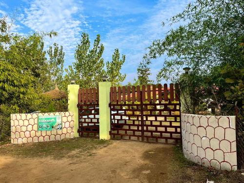 a wooden fence with a gate in a yard at Grand Narmada Jungle Homestay Resort-Bandhavgarh in Tāla