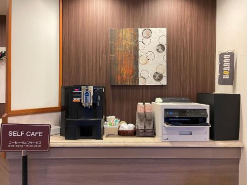 a coffee shop with a coffee machine on a counter at Hotel Route-Inn Akita Tsuchizaki in Akita