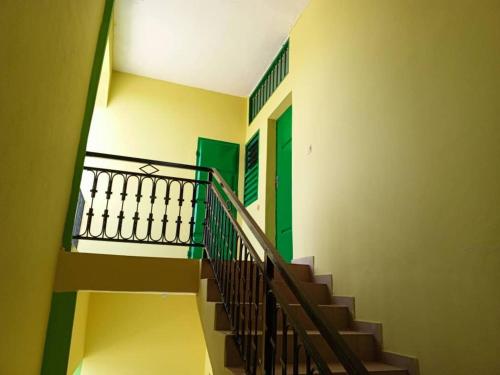 una escalera en un edificio con una puerta verde en Appat'Adjanohoun en Ouidah