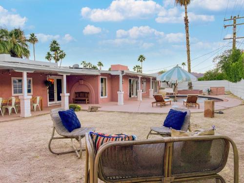 een huis met stoelen en een tafel en een parasol bij Casita Suenito in Palm Springs