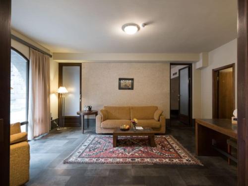 a living room with a couch and a table at Tufenkian Avan Dzoraget Hotel in Dzoraget