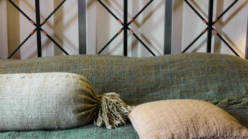 a pillow sitting on top of a green couch at Tufenkian Avan Dzoraget Hotel in Dzoraget