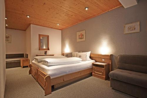 - une chambre avec un grand lit et un canapé dans l'établissement Appartements Charlotte, à Westendorf