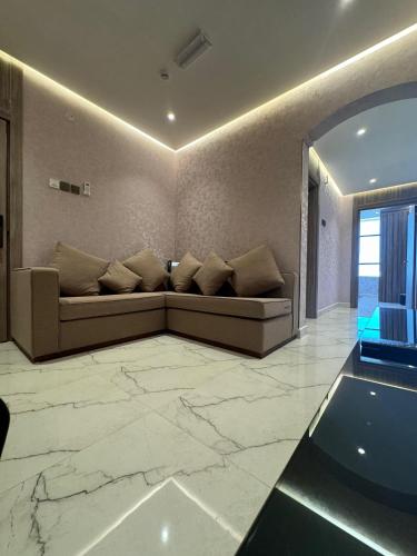 a living room with a couch on a marble floor at Royal Plaza Hotel in Duqm