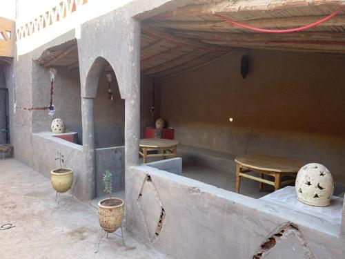 a room with two tables and a table and chairs at GITE Take your time in Merzouga