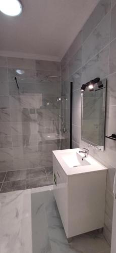 y baño con lavabo, ducha y espejo. en Apartamento com Piscina em Albufeira, Praia da Oura, en Albufeira