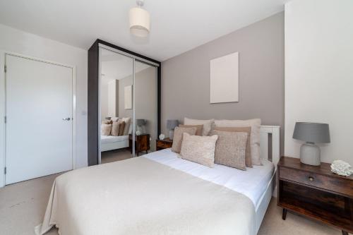 a bedroom with a large white bed and a mirror at The Park Royal Collection in London