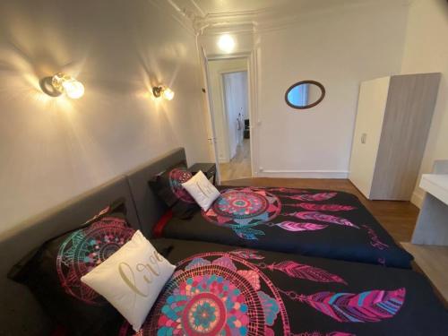 Zimmer mit 2 Betten und einem Sofa mit Kissen in der Unterkunft Appt 2ch, gare 2 mn, Paris 15 mn in Villeneuve-Saint-Georges