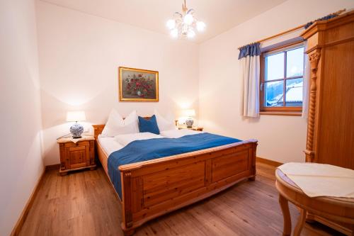 1 dormitorio con cama con sábanas azules y ventana en Chalet Isabella, en Westendorf
