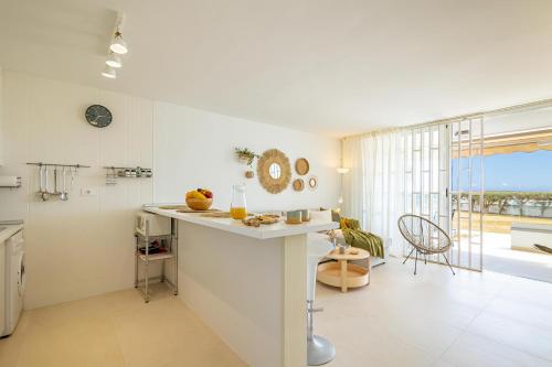 a white kitchen with a counter and a large window at HORIZON VACATION HOME - Firstline Las Burras in San Bartolomé de Tirajana