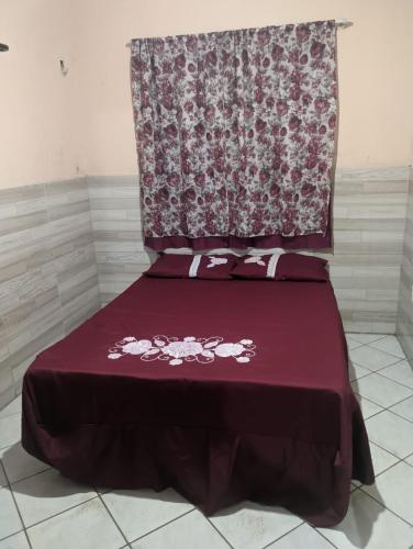 Cama en habitación con colcha roja en Casa da Edileusa en Barreirinhas