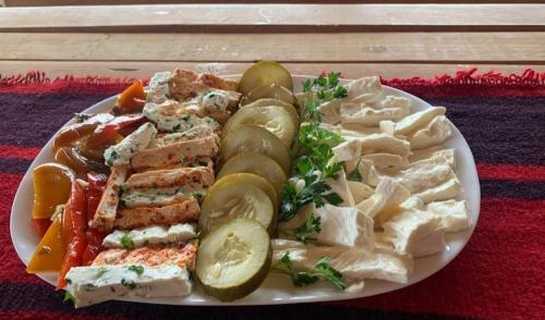 un plato de comida con pollo y verduras en una mesa en Cottages Jasavić, en Plav