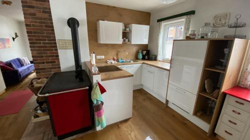 a kitchen with white cabinets and a refrigerator at 11er Häusl in Flachau