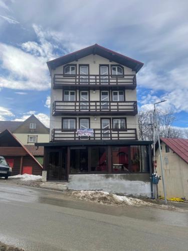 een hoog gebouw aan de kant van een straat bij Pensiunea White House in Straja