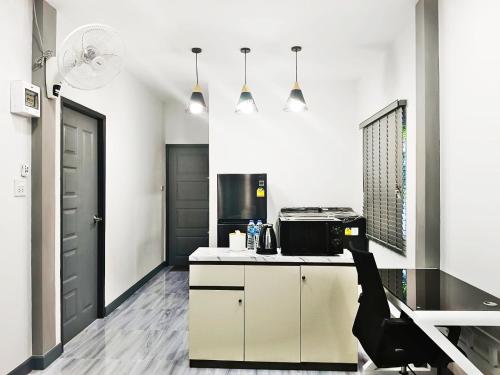 a kitchen with white cabinets and a black door at The Engineer's Villas, Krabi in Ban Khlong Chi Lat