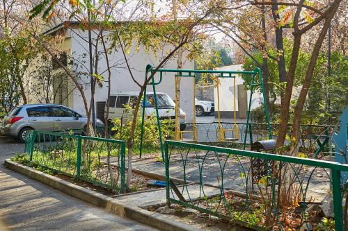 a park with a swing set on the side of a street at DeLuxe Ap Almaty Центр in Almaty