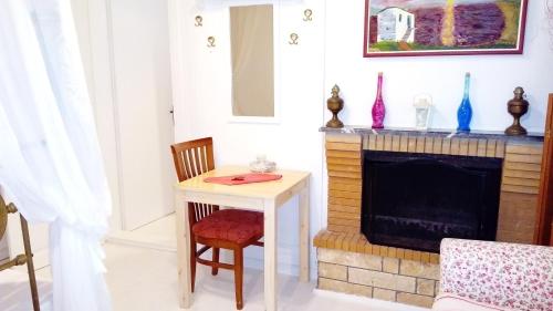 a living room with a table and a fireplace at ZACHAROULA ROOMS 2 in Manganítis