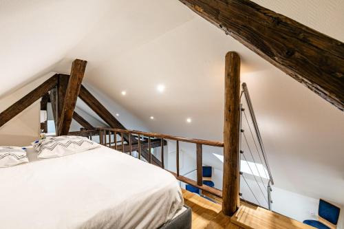 Bett in einem Zimmer mit Holzbalken in der Unterkunft Le Chêne - Appt au calme pour 5 in Quatzenheim