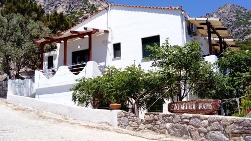 a white house with a sign in front of it at ZACHAROULA ROOMS 2 in Manganítis