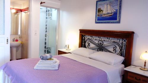 a bedroom with a purple bed with towels on it at ZACHAROULA ROOMS 2 in Manganítis