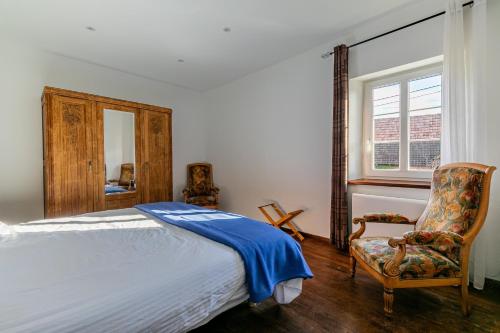 ein Schlafzimmer mit einem Bett, einem Stuhl und einem Fenster in der Unterkunft Le Houblon - Appt refait à neuf au calme in Quatzenheim