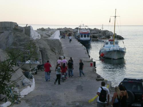 a group of people walking along a dock with boats at ZACHAROULA ROOMS 2 in Manganítis