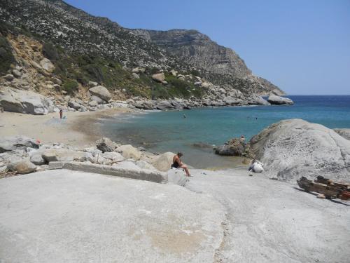 a man standing on a beach next to the water at ZACHAROULA ROOMS 2 in Manganítis