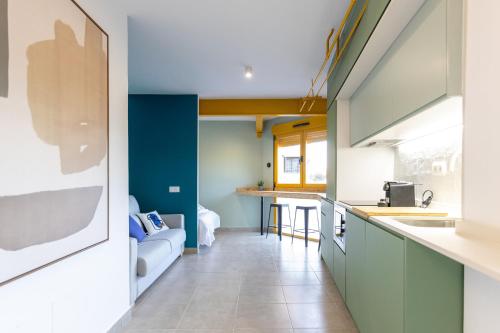 a kitchen with green cabinets and blue walls at Estudio moderno y acogedor en Madrid Rio nº 9 in Madrid