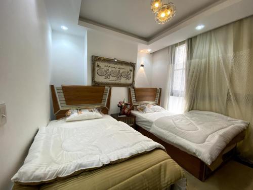 two twin beds in a room with a window at شقة فندقية بالمعادى 116 in Cairo