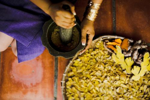 a person holding a spoon next to a bowl of food at Banteay Srey Women's Only Traditional Spa and Homestay in Kampot