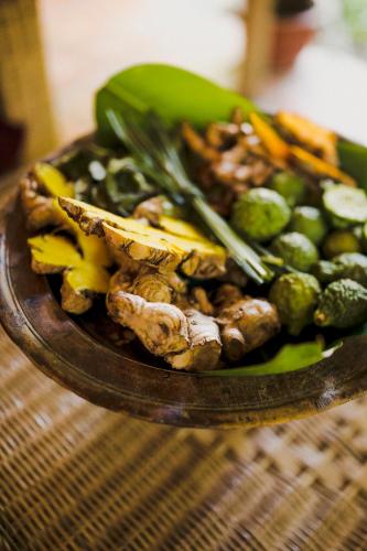 a plate of fruit and vegetables on a table at Banteay Srey Women's Only Traditional Spa and Homestay in Kampot