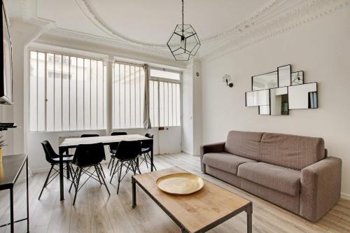 a living room with a couch and a table at Cosy apartment-6P-PigalleLafayette in Paris