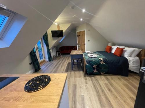 Dormitorio con cama y escritorio en el ático en Roseberry Barn, Bullamoor, Northallerton, North Yorkshire, en Brompton