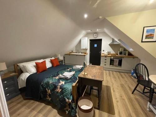 1 dormitorio con cama, escritorio y cocina en Roseberry Barn, Bullamoor, Northallerton, North Yorkshire, en Brompton