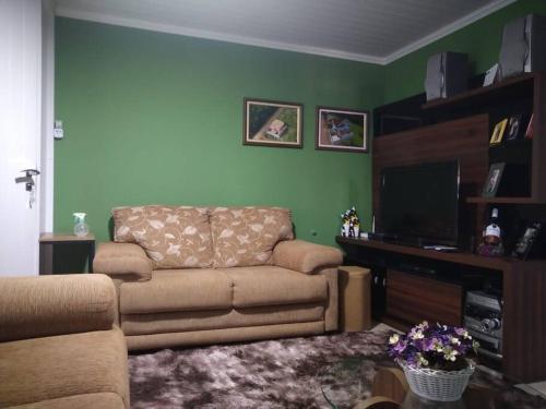a living room with a couch and a flat screen tv at Casa em Pomerode_SC in Pomerode